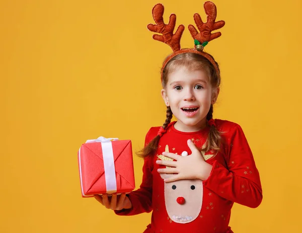 Überraschte lustige Kindermädchen im weihnachtlichen Rentierkostüm mit — Stockfoto