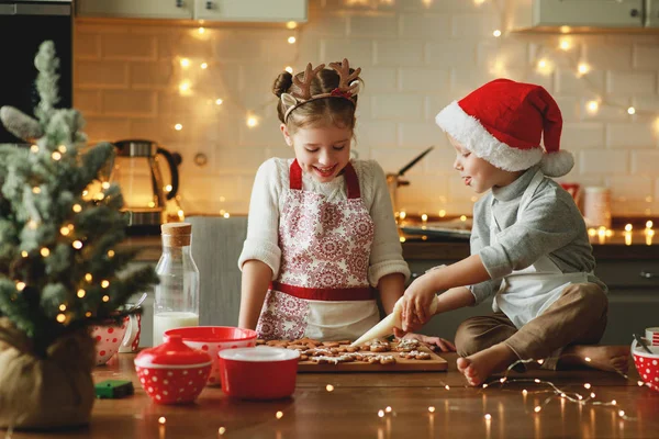 Happy children boy and girl bake christmas cookies — Stock Photo, Image