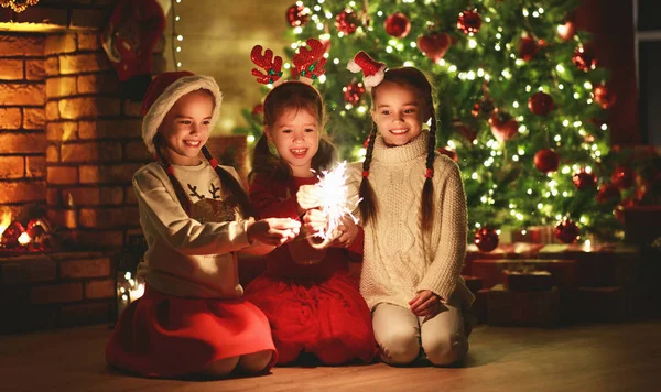 Crianças alegres felizes com faíscas e fogos de artifício perto do Natal — Fotografia de Stock