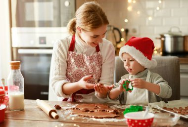 Mutlu aile anne ve çocuğu Noel kurabiyesi pişirir.
