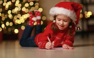 Mutlu çocuk Noel Baba 'nın evine mektup yazıyor.
