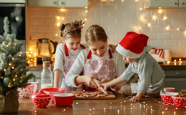 Счастливая семья мать и дети пекут рождественское печенье — стоковое фото