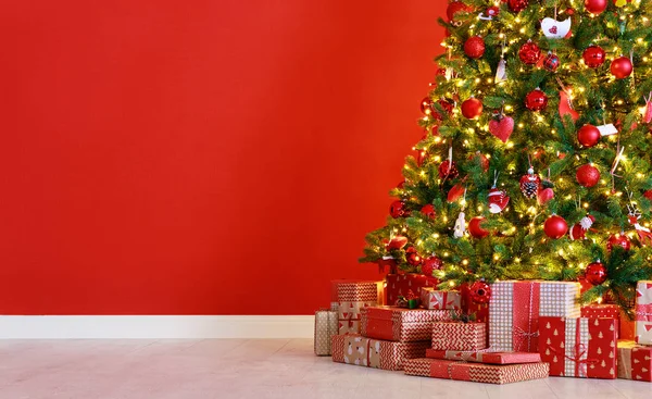 Christmas tree on the background of   red empty wal — Stock Photo, Image