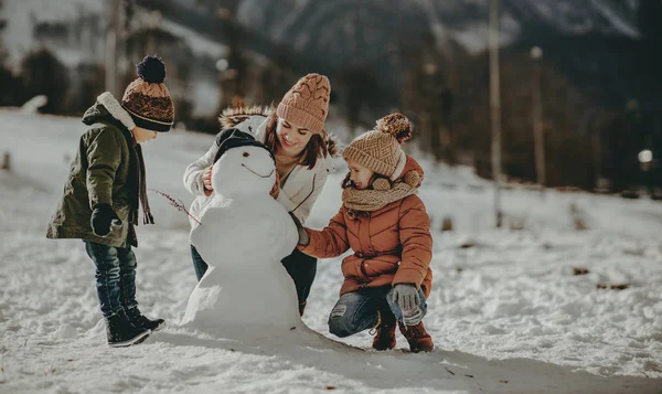 Mutlu aile anne ve çocukları kış tatilinde eğleniyorlar. — Stok fotoğraf