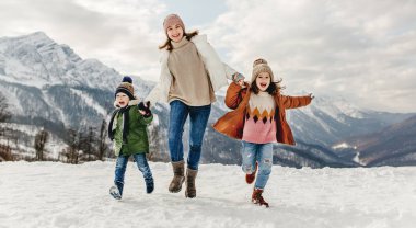 Mutlu aile anne ve çocukları kış tatilinde eğleniyorlar.