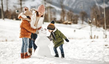 Mutlu aile anne ve çocukları kış yürüyüşünde eğleniyorlar.