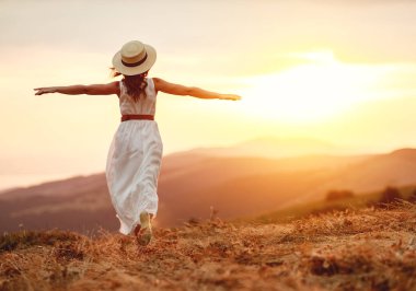   Mutlu kadın doğada gün batımında sırtı ile ayakta  