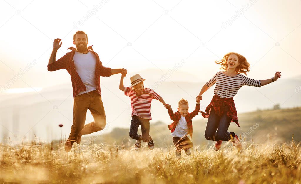 Happy family: mother, father, children son and daughter jumping 