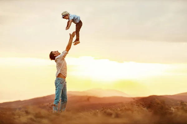 Gelukkig familie vader en zoon in de natuur bij zonsopgang — Stockfoto