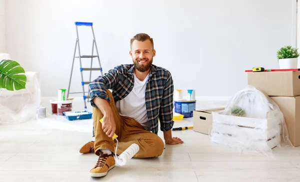 Repair in apartment. Happy man paints wall — Stock Photo, Image