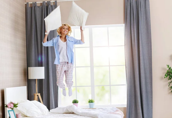 Happy young woman laughing and jumping on the bed in   morning a — Stock Photo, Image