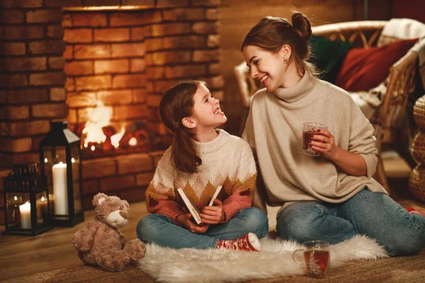 Rodzinna matka i dziecko czytają książki i piją herbatę w zimową noc — Zdjęcie stockowe