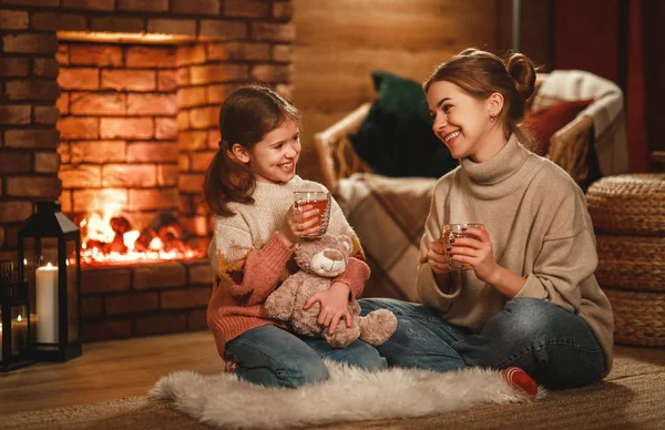 Rodzinna matka i dziecko czytają książki i piją herbatę w zimową noc — Zdjęcie stockowe