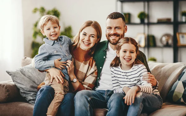 Mutlu aile anne baba ve çocuklar evde kanepede — Stok fotoğraf