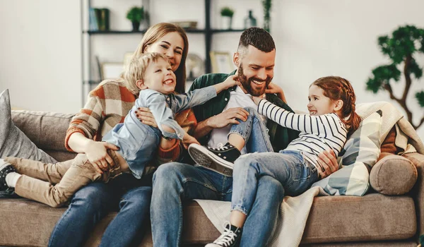 Mutlu aile anne baba ve çocuklar evde kanepede — Stok fotoğraf