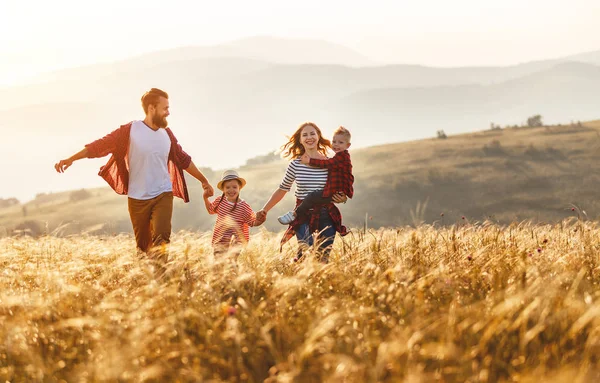 Pai de família feliz de mãe e filho de criança na natureza no pôr do sol — Fotografia de Stock