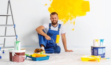 Dairenin tamiri. Mutlu işçi duvarı boyuyor. 