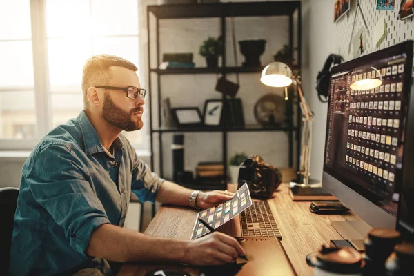 Jonge man is een freelance fotograaf werken op de computer — Stockfoto