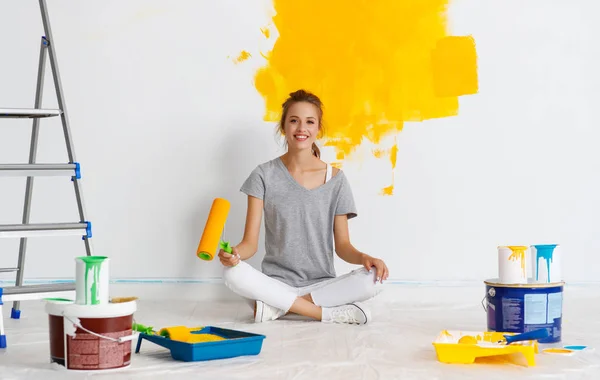 Oprava v bytě. Šťastná mladá žena maluje stěnu — Stock fotografie
