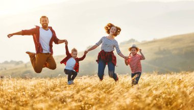 Mutlu aile: anne, baba, çocuk, oğul ve kız atlama 