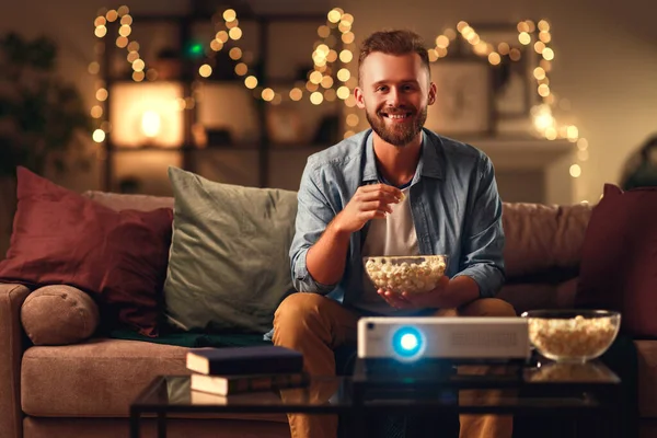 Young man watching projector tv at home in   evening alon — Stock Photo, Image