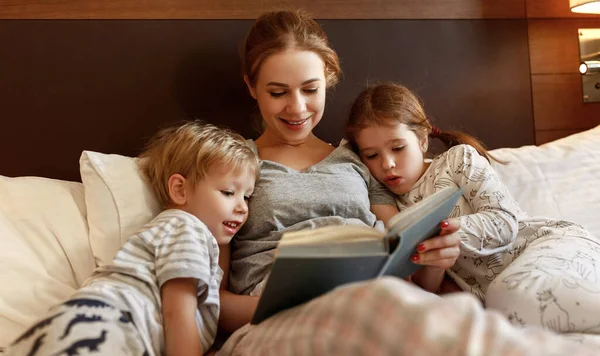 Avond familie lezing. moeder leest kinderen. boek voor goin — Stockfoto