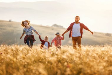 Mutlu aile: anne, baba, çocuk, oğul ve kız koşuyor.