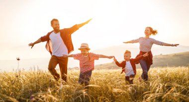 Mutlu aile: anne, baba, çocuk, oğul ve kız koşuyor.