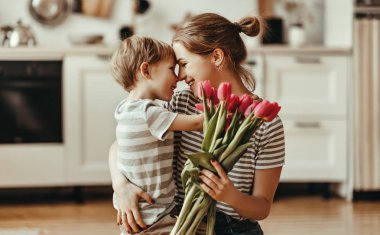 happy mother's day! child son gives flowers for  mother on holid clipart