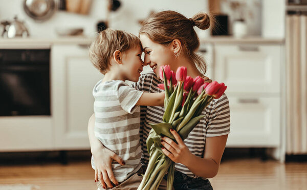 happy mother's day! child son gives flowers for  mother on holid