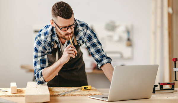 young male carpenter working in  worksho