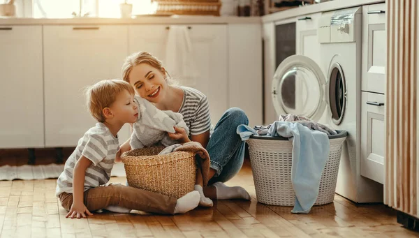 Família feliz mãe dona de casa e filho na lavanderia com lavatório — Fotografia de Stock
