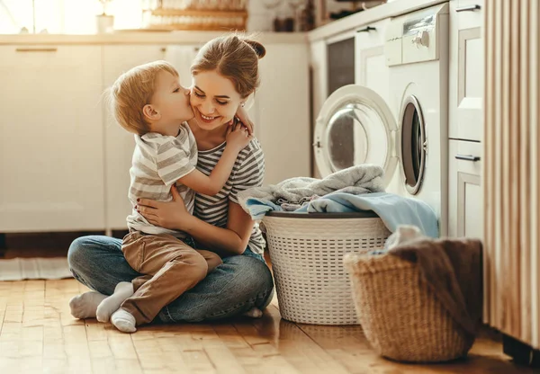 Feliz familia madre ama de casa y el niño en la lavandería con lavabo — Foto de Stock