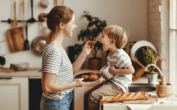Подготовка семейного завтрака. Мать и ребенок сын режут хлеб — стоковое фото