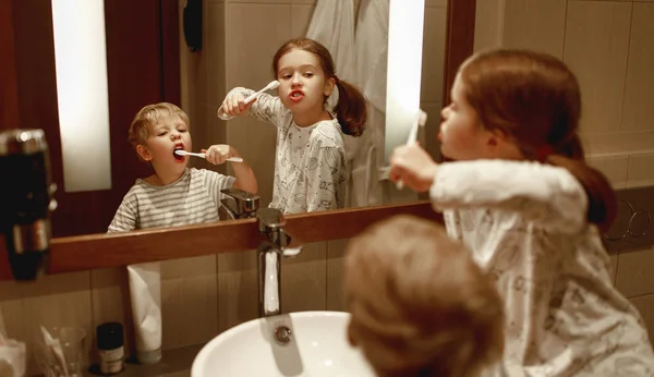 快乐有趣的男孩和女孩在家里刷牙 — 图库照片