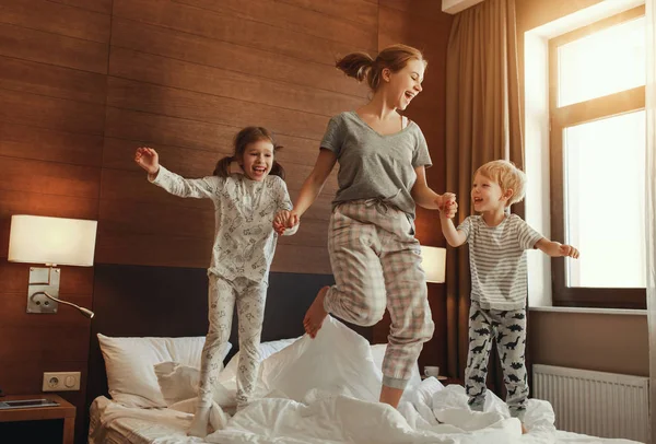 Glückliche Familienmutter und Kinder Sohn und Tochter springen, lachen — Stockfoto