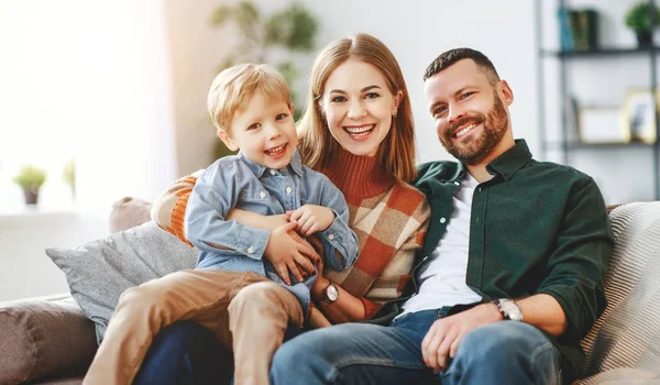 Feliz familia madre padre y niño hijo en casa en el sofá — Foto de Stock