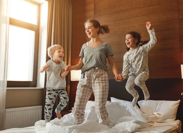 Счастливая семья мать и дети сын и дочь прыгать, смеяться — стоковое фото