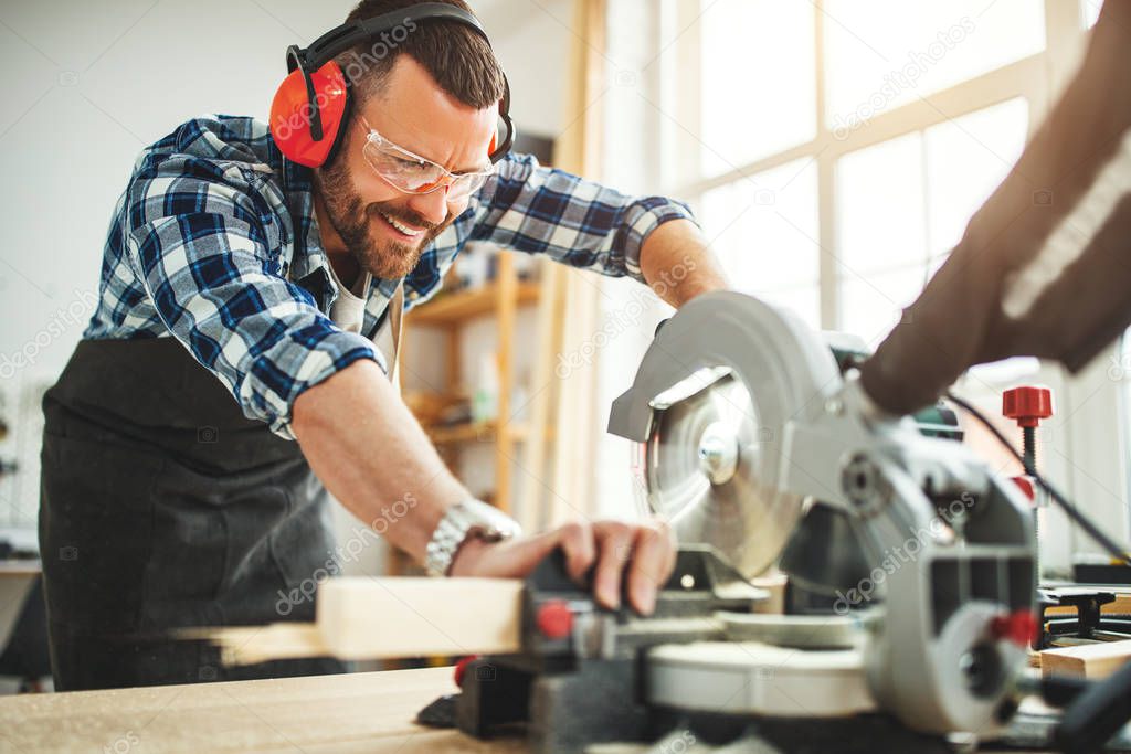 young male carpenter working in  worksho