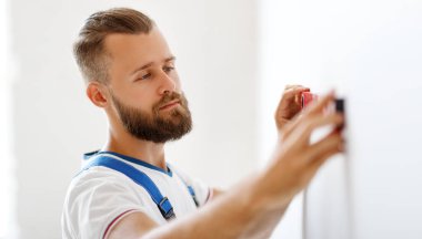 Erkek işçi düz hiza duvarlarıyla onarım yapıyor