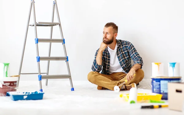 Reparatie in het appartement. trieste man schildert muur — Stockfoto