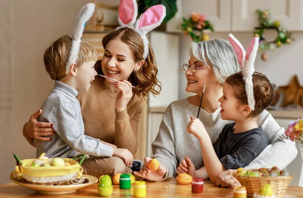 Счастливой Пасхи! мать семьи, бабушка и дети красят яйца — стоковое фото