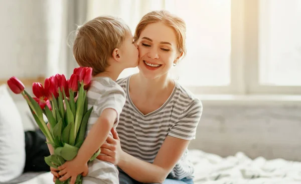 Gelukkige Moederdag! kind zoon geeft bloemen voor moeder op holid — Stockfoto