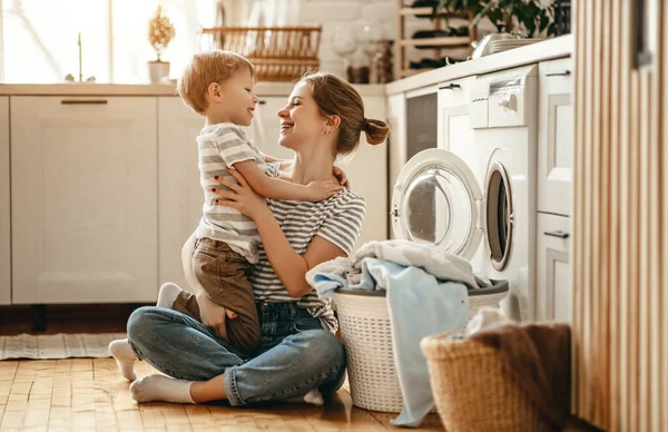 Happy family mother housewife and child   in laundry with washin — Stock Photo, Image
