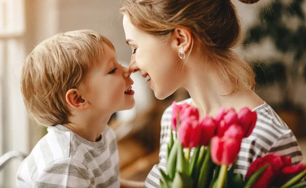 happy mother's day! child son congratulates mother on holiday and gives flower