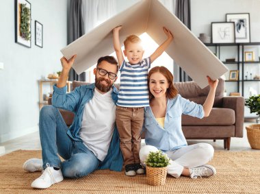 genç bir aile konut kavramı. Anne baba ve çocuk yeni evde bir hom bir çatı ile