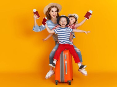 İyi yolculuklar! Gezginler ailesi çantalı anne ve çocuklar... biletleri ve pasaportları renkli sarı arka grupta.