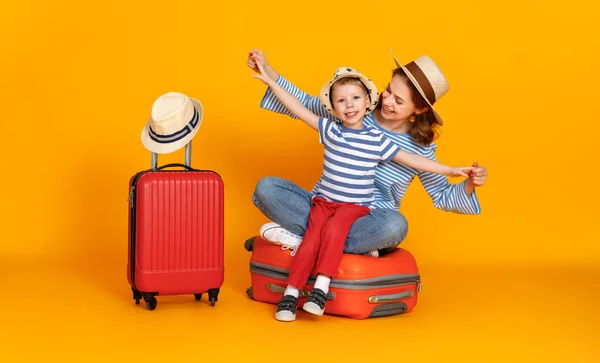 ハッピー ジャーニー 旅行者の家族黄色の背景にスーツケースのチケットとパスポートを持つ母親と子供 — ストック写真