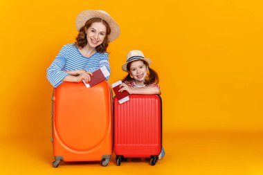 İyi yolculuklar! Gezginler ailesi çantalı anne ve çocuk. Biletler ve pasaportlar renkli sarı arka grupta.