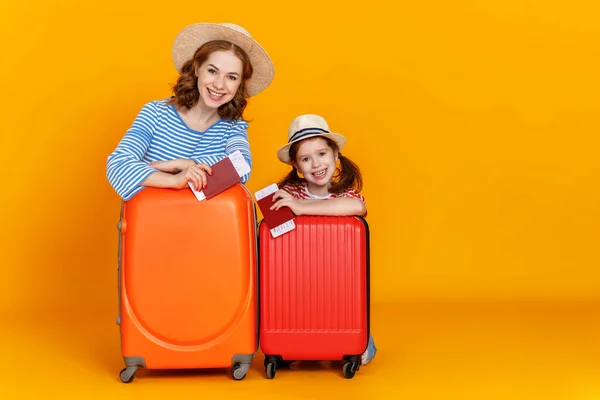 ハッピー ジャーニー 旅行者の家族黄色の背景にスーツケースのチケットとパスポートを持つ母親と子供 — ストック写真